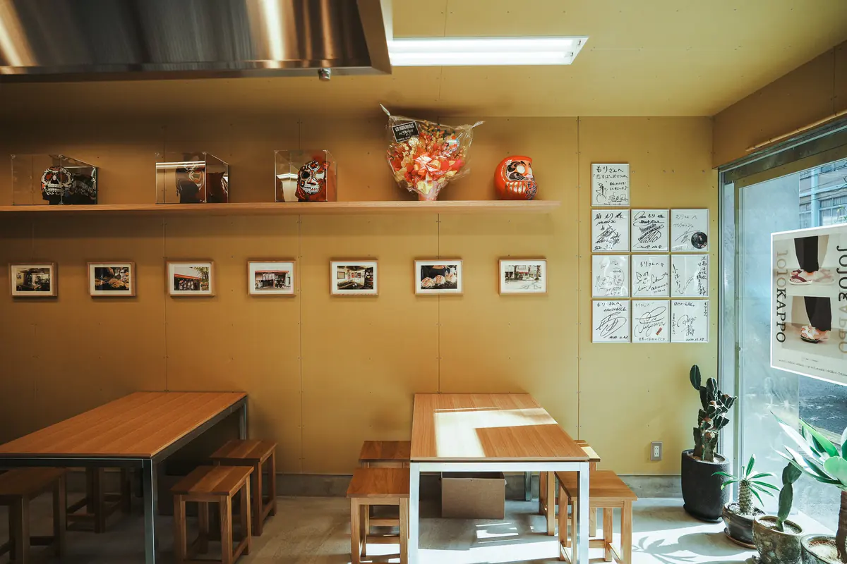写真が並ぶテーブル席 / Table seating